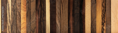 Wood background wide format. Various kinds of exotic woods in vertical strips.