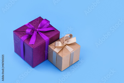 Two boxes with gifts in an elegant package with ribbons and bows. Blue background, copy space. © Kot63