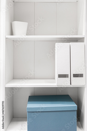A minimalist wardrobe, half-empty shelves in a white wardrobe.