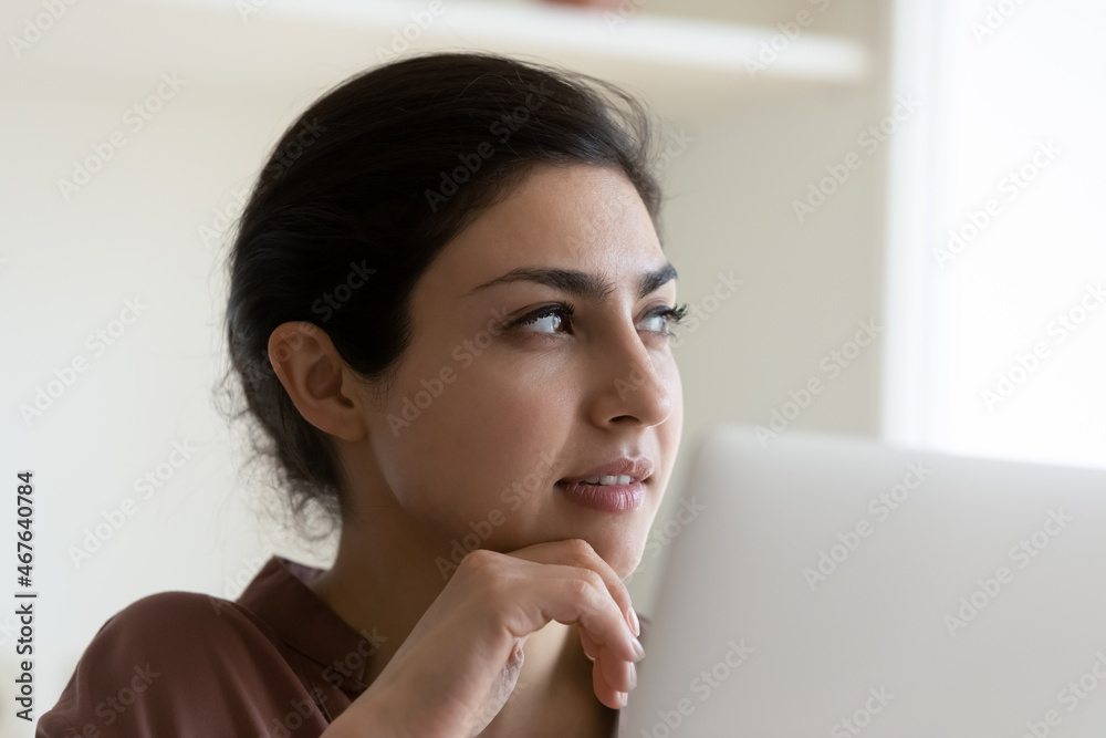 Thoughtful Indian businesswoman sit by laptop looks aside ponder on business task, plan creative startup, work on computer lost in thoughts, close up. Brainwork, business vision, new project concept Thoughtful Indian businesswoman sit by laptop looks aside ponder on business task, plan creative startup, work on computer lost in thoughts, close up. Brainwork, business vision, new project concept