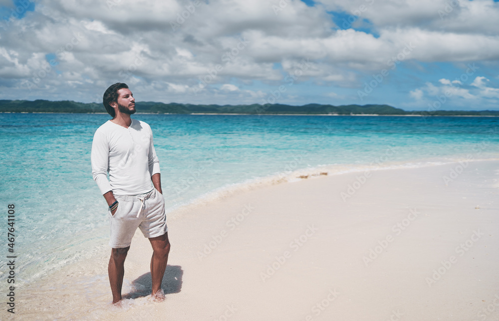 Tropical vacation. Portrait of young handsome man on the white sand beach. Tropical vacation. Portrait of young handsome man on the white sand beach.