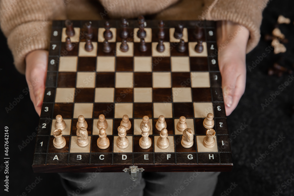 Chess board with wooden chess pieces in female hands, top view. Chess board with wooden chess pieces in female hands, top view.