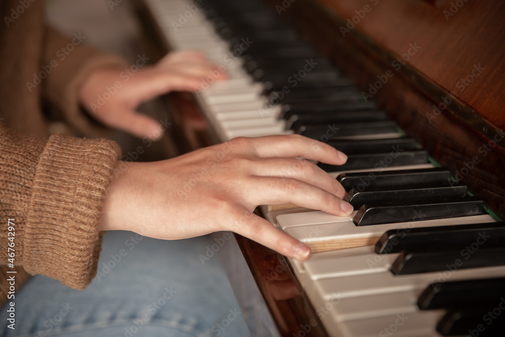 Fototapeta premium Close-up of female hands playing the piano.