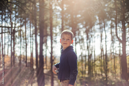 Portrait boy in forest park. Happy Kid is playing in park outdoors