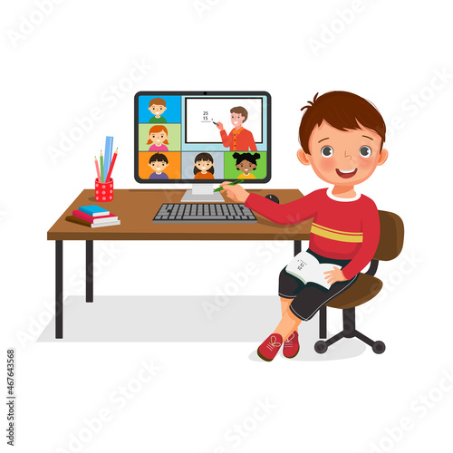 Cute little boy connecting with other school children via teleconference or virtual class online on computer. Study from home concept for student using video conference at homeschooling.