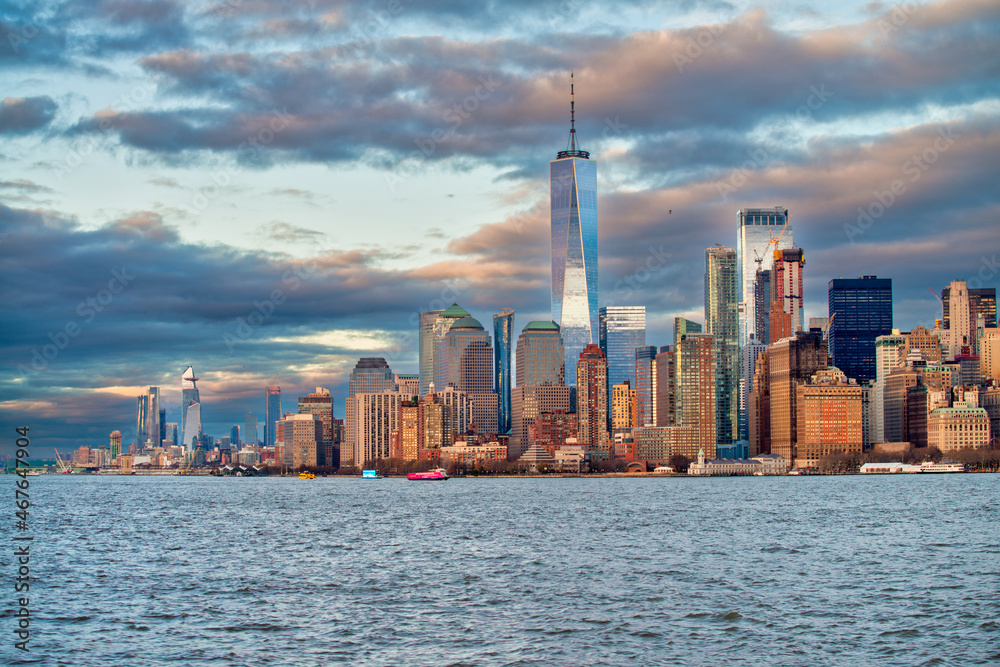 Sunset view of Lower Manhattan skyline from a boat in New York H
