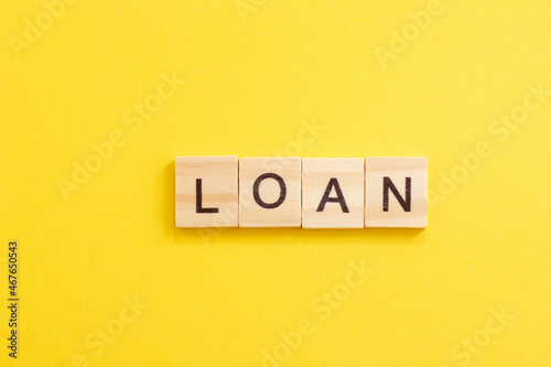Wooden word LOAN. Concept of buying an apartment or house in debt