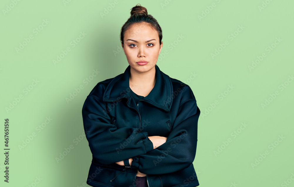 Young hispanic girl wearing sportswear skeptic and nervous, disapproving expression on face with crossed arms. negative person. Young hispanic girl wearing sportswear skeptic and nervous, disapproving expression on face with crossed arms. negative person.