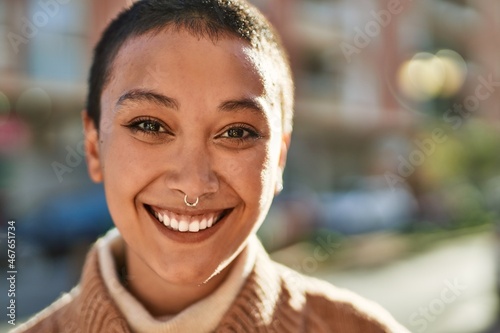 Beautiful hispanic woman with short hair smiling happy outdoors