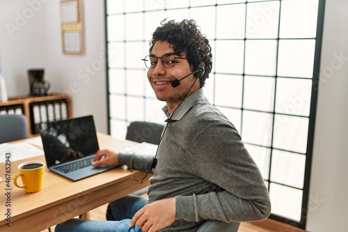 Young hispanic call center agent man smiling happy working at the office.