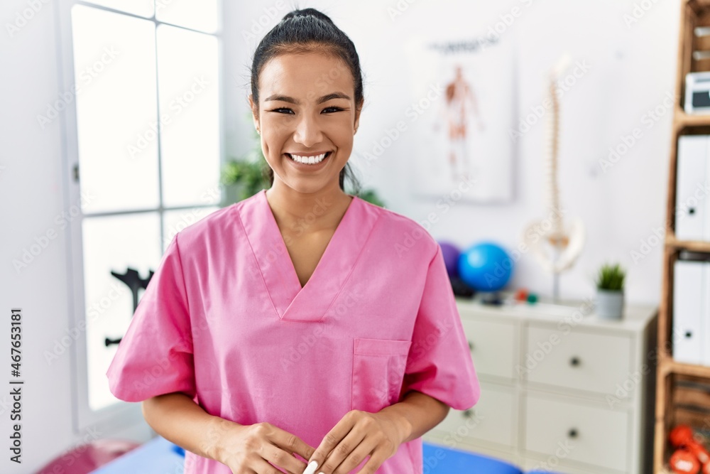 Young hispanic woman working at pain recovery clinic with a happy and cool smile on face. lucky person. Young hispanic woman working at pain recovery clinic with a happy and cool smile on face. lucky person.