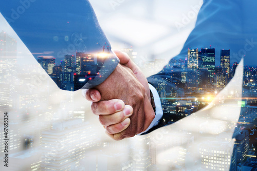 Partnership. multi exposure of investor businessman handshake with partner for successful meeting with night city background, digital technology, investment, negotiation, partnership, teamwork concept photo