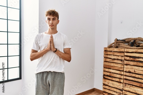 Young caucasian man training yoga at sport center