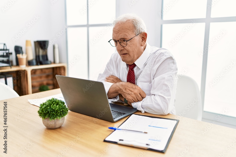 Senior man working at the office using computer laptop looking sleepy and tired, exhausted for fatigue and hangover, lazy eyes in the morning. Senior man working at the office using computer laptop looking sleepy and tired, exhausted for fatigue and hangover, lazy eyes in the morning.