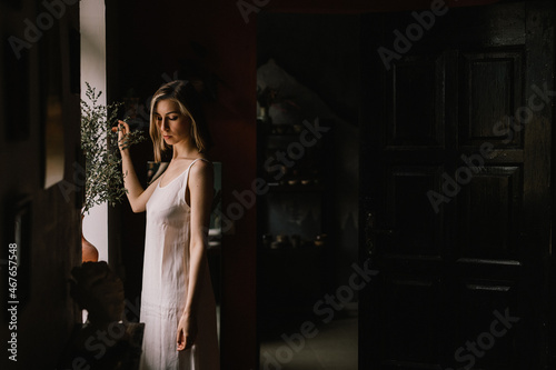 talented sculptor girl in light negligee stands in pottery workshop near large window. concept is beauty and art.