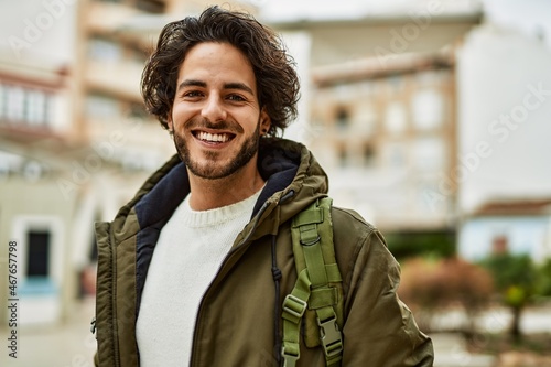 Handsome hispanic man smiling at the city