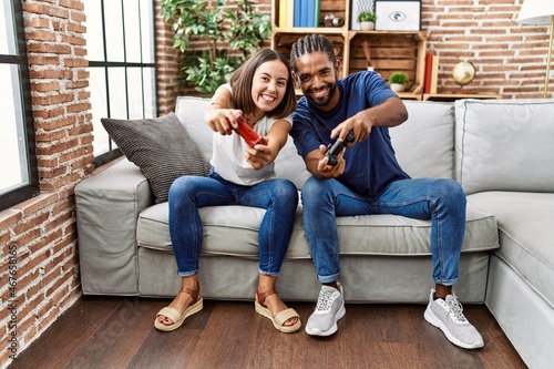 Man and woman couple smiling confident playing video game at home