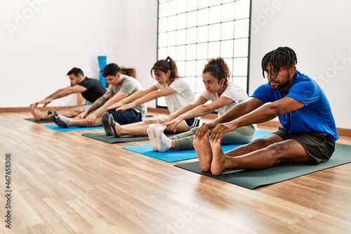 Group of young sporty people concentrate training yoga at sport center.