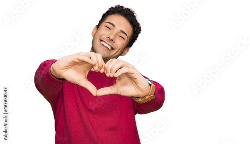 Young handsome man wearing casual clothes smiling in love doing heart symbol shape with hands. romantic concept.