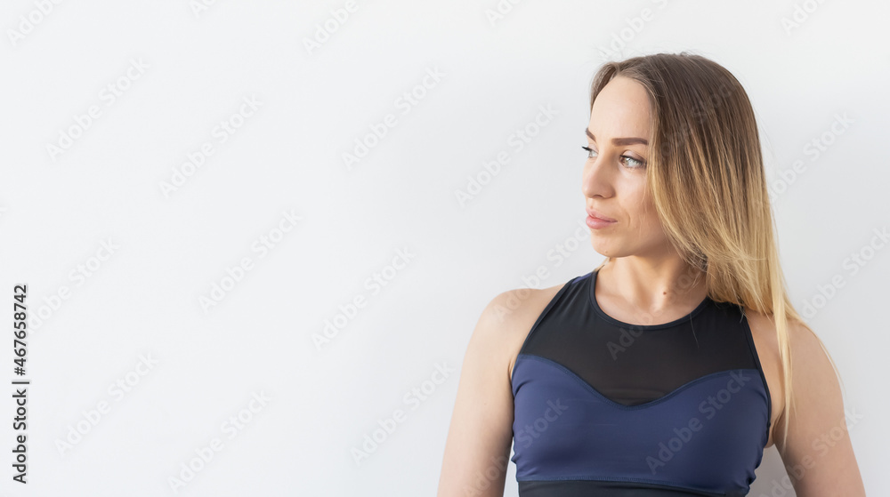 Portrait of woman standing against white background with copy space. Female in fitness wear relaxing after workout. Fit and strong athlete fitness girl Portrait of woman standing against white background with copy space. Female in fitness wear relaxing after workout. Fit and strong athlete fitness girl