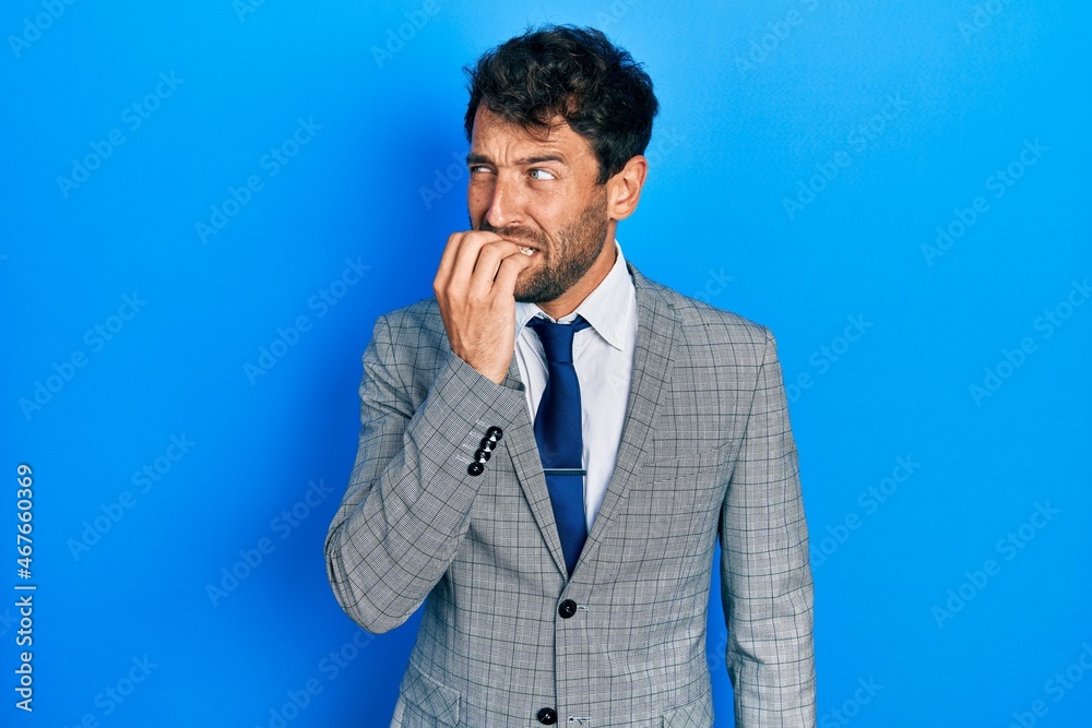 Handsome man with beard wearing business suit and tie looking stressed and nervous with hands on mouth biting nails. anxiety problem. Handsome man with beard wearing business suit and tie looking stressed and nervous with hands on mouth biting nails. anxiety problem.
