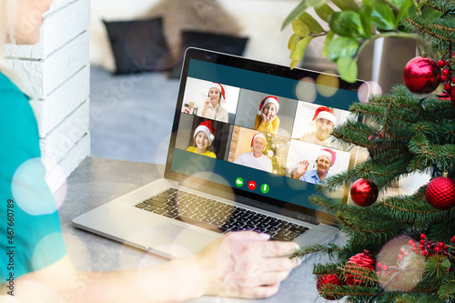 Christmas greetings online. a woman in a white sweater and red Santa hat uses a laptop to make video calls to friends, parents, and for online shopping