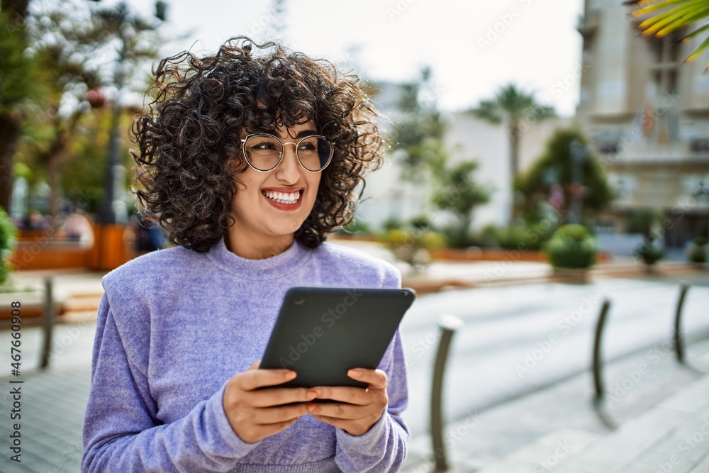 Young middle east woman smiling confident using touchpad at street Young middle east woman smiling confident using touchpad at street
