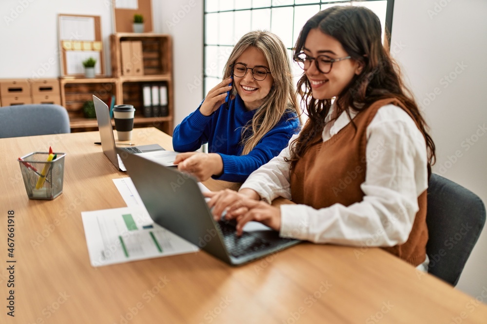 Two business workers woman talking on the smartphone and using laptop at the office. Two business workers woman talking on the smartphone and using laptop at the office.