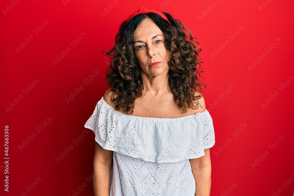 Middle age hispanic woman wearing casual clothes relaxed with serious expression on face. simple and natural looking at the camera.