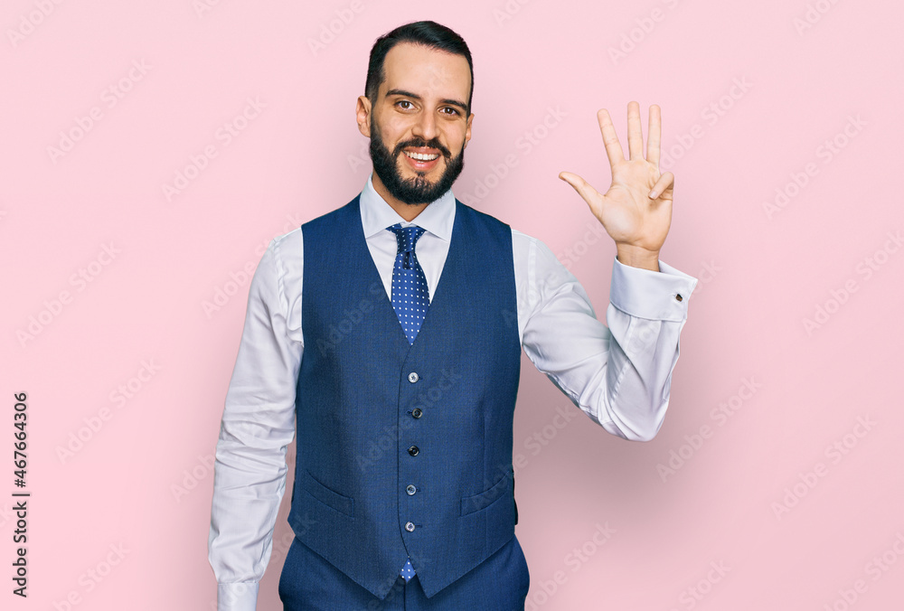 Young man with beard wearing business vest showing and pointing up with fingers number four while smiling confident and happy. Young man with beard wearing business vest showing and pointing up with fingers number four while smiling confident and happy.
