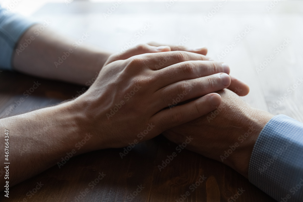 You are not alone daddy. Close up of young man hands covering wrinkled palms of mature old man grandfather help in difficult life situation. Compassionate grown son support father retiree in crisis