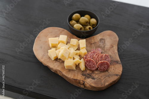 antipasti on olive board on black wood table