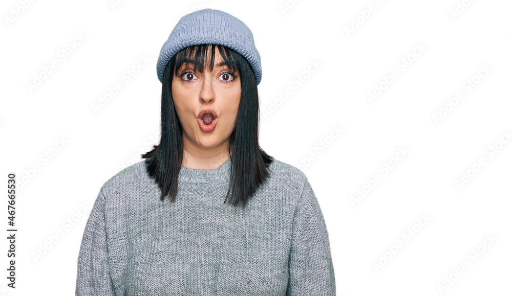 Young hispanic woman wearing cute wool cap afraid and shocked with surprise expression, fear and excited face. Young hispanic woman wearing cute wool cap afraid and shocked with surprise expression, fear and excited face.