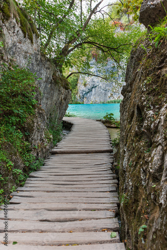 wooden hiking trail in a colorful forest with clear lakes and impressive waterfalls, Plitvice National Park, Croatia,
