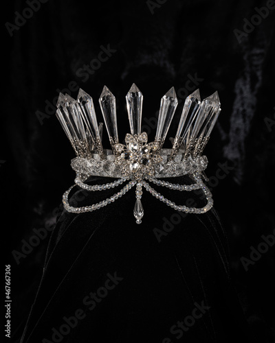 beautiful silver crown with crystals on a black shiny background, accessory headdress, close-up