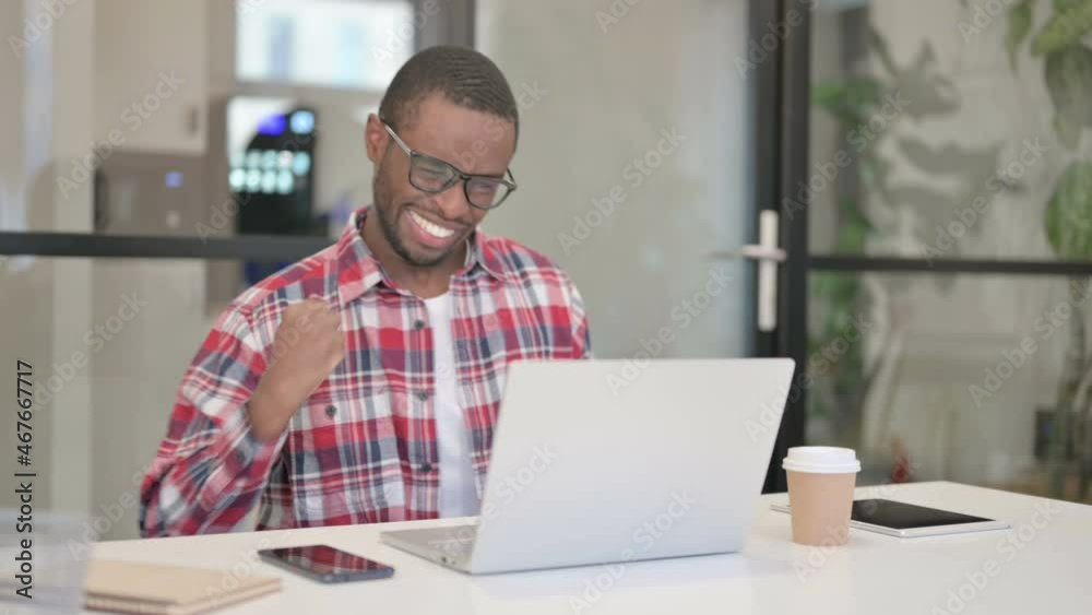 African Man Celebrating Success while using Laptop