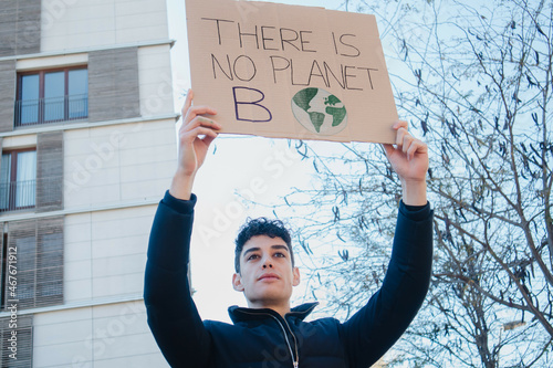 Obraz na plátne Arab teenager with climate change banner on environment demonstration