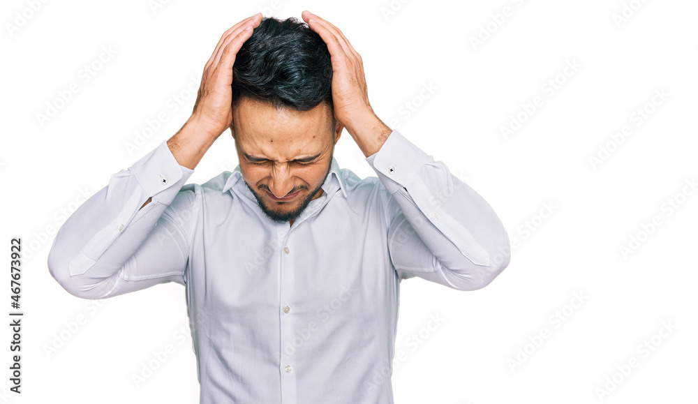 Young arab man wearing casual clothes suffering from headache desperate and stressed because pain and migraine. hands on head. Young arab man wearing casual clothes suffering from headache desperate and stressed because pain and migraine. hands on head.