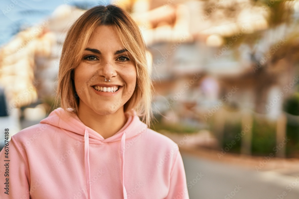 Young blonde sporty girl smiling happy standing at the city. Young blonde sporty girl smiling happy standing at the city.