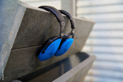 Close up of two blue hearing protectors in an industrial environment