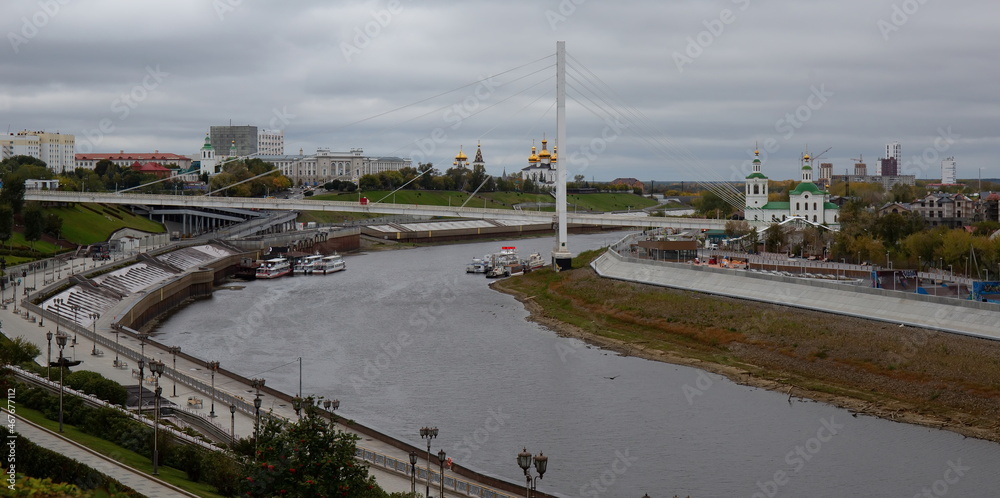 View from the granite embankment to the bridge of lovers in the city of Tyumen in autumn View from the granite embankment to the bridge of lovers in the city of Tyumen in autumn