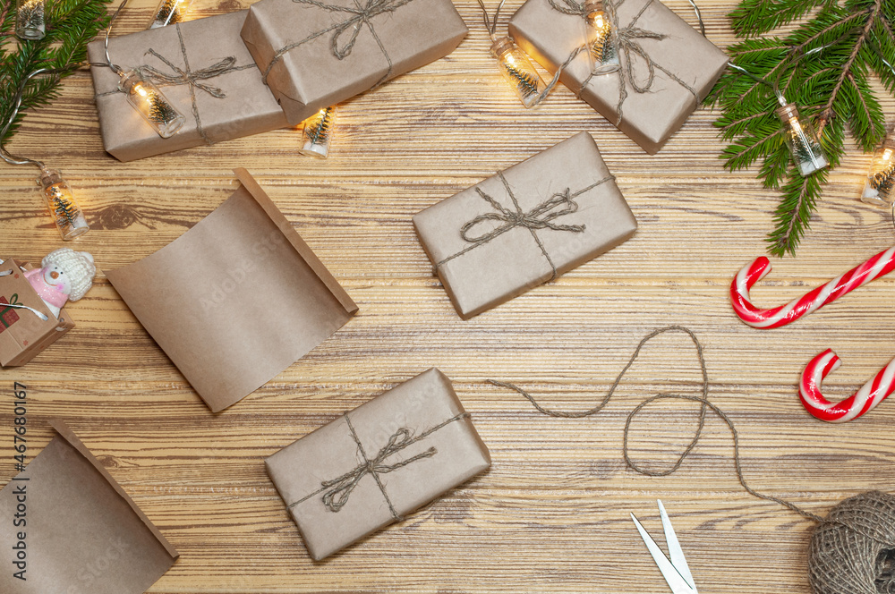 Christmas. Preparation for the holiday. Layout of items on the New Year's theme. Holiday gifts in packaging. DIY gift wrapping in craft paper.  Wooden background. 