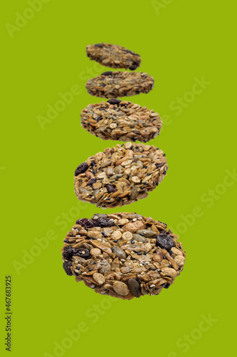 Cereal Cookies homemade with falling in the air. Healthy food, Whole grain cookies, isolated on green background, Selective focus, Clipping path.