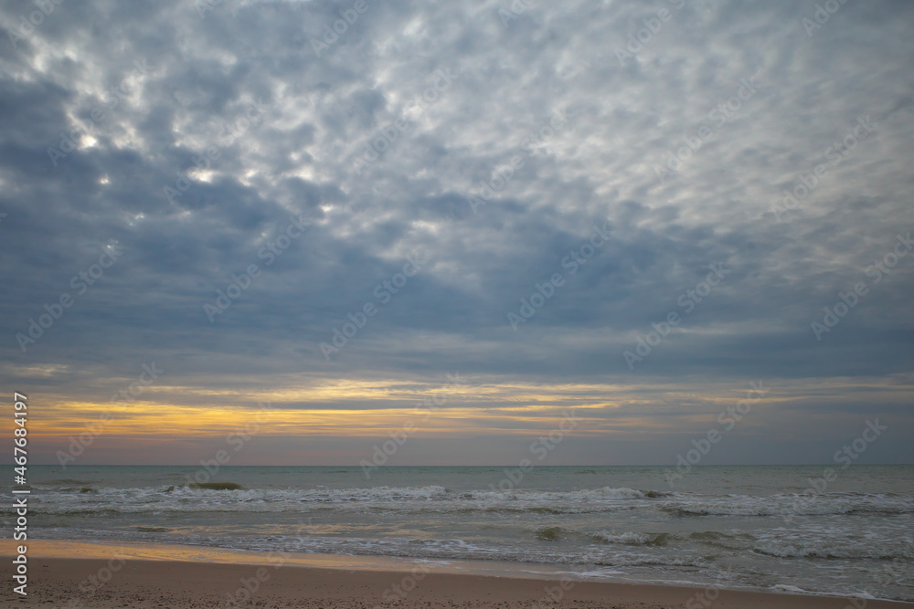 Golden hour. Sandy shore. Sunset sky.