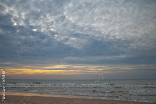 Golden hour. Sandy shore. Sunset sky.