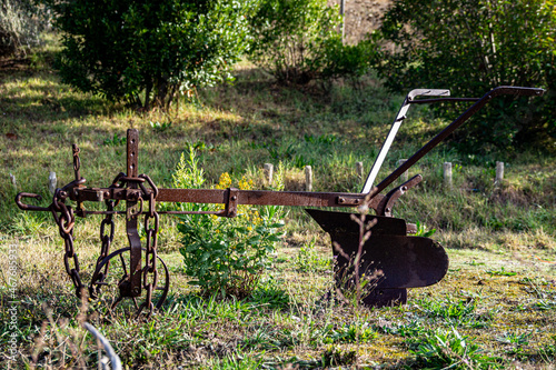 Old agricultural machinery. Old rusty plow on the edge of a agricultural field