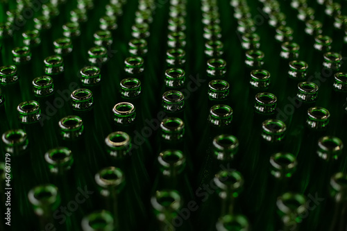 Glass factory, industrial production of glass containers. A lot of empty glass bottles as a background of green glass containers with copy space. Bottles for drinks. Technological work at the factory.