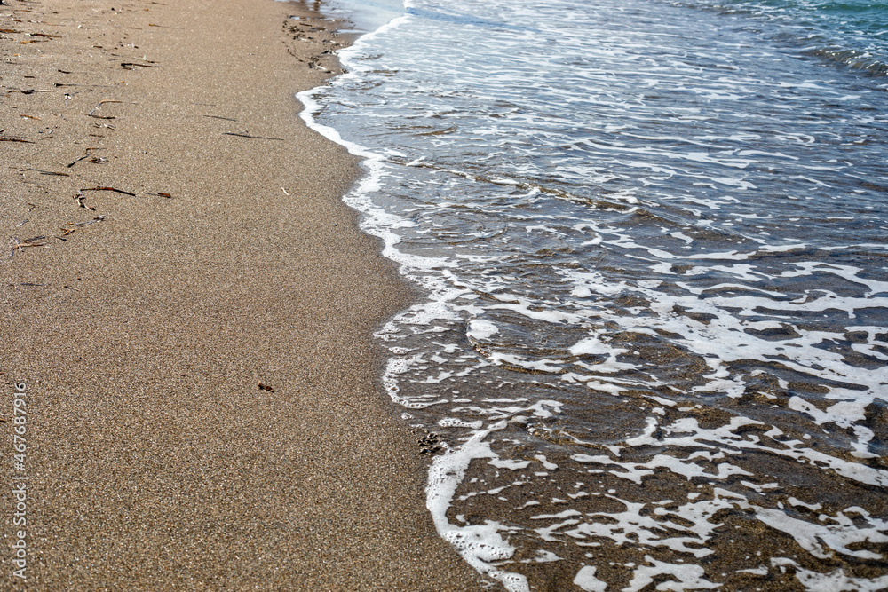 blurred sea background surf with foam on sandy beach top view, horizontal blurred sea background surf with foam on sandy beach top view, horizontal