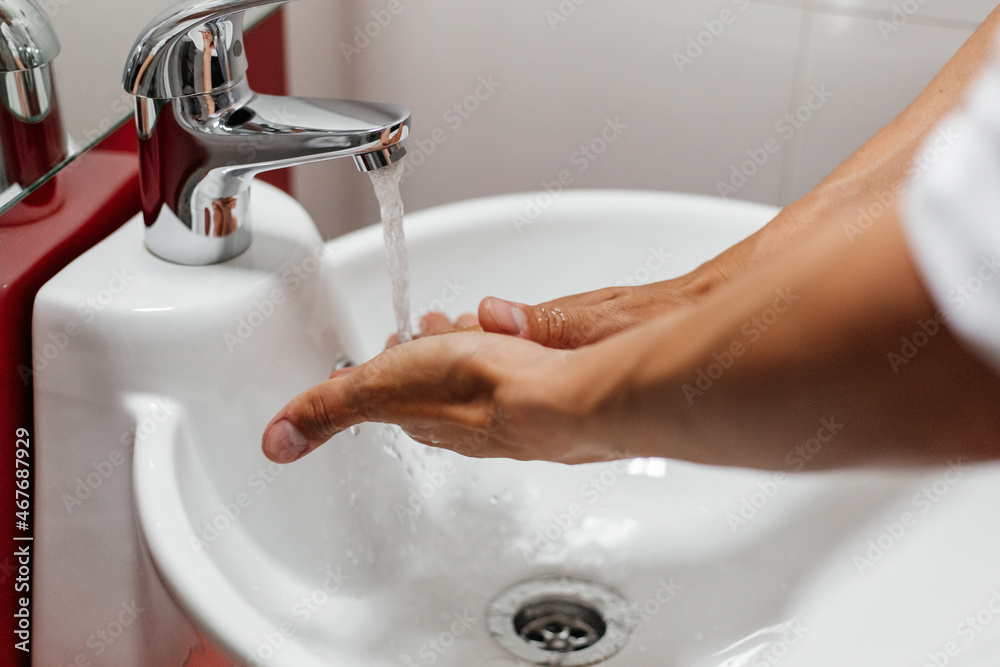 Washing men's hands under running water in the bathroom over the sink. Washing men's hands under running water in the bathroom over the sink.