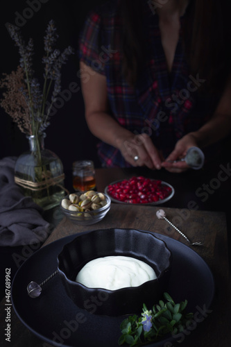  Preparing food at home. Preparing yogurt with fresh fruit. Woman cooking.